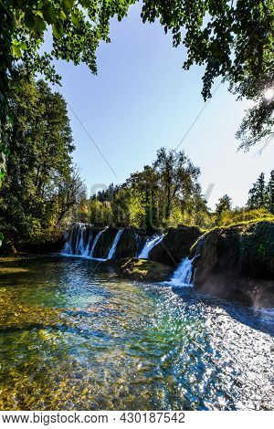  The small Croatian town of Slunj. Dense forests surround the city and the river. Magnificent cascade of waterfalls on the Korana River. The concept of ecological, active and photo tourism