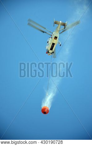 Russian KA-32 helicopter draws water from the sea to extinguish a forest fire. 30 July, 2021. Marmaris,Turkey