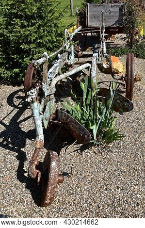 An Old Two Bottom Steel Plow Serves As A Backyard Decoration