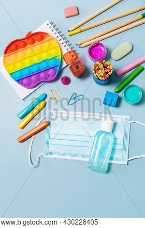 School Supplies, Poppit Anti-stress, Face Mask, Bottle Of Sanitizer, For Back To School On A Blue Ba