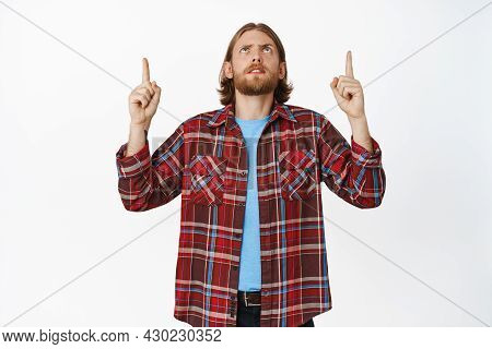 Cringe. Confused And Displeased Adult Blond Man Frowning Upset, Pointing Fingers Up And Looking Upwa