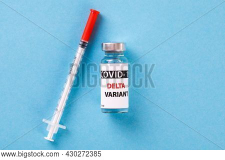 Vaccine bottles covid - 19 delta variant, vials medicine and syringe injection isolated on blue. Coronavirus DELTA 2019-ncov.