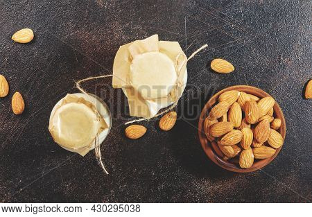 Plant Based Almod Milk In Bottles On Brown Background. Copy Space. Top View