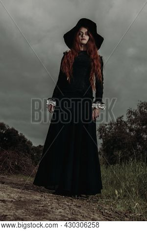 A portrait of a lonely dark witch near the forest. Magic, dark force, spell. 