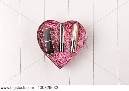 Makeup Cosmetics In Heart Shape Box On Wooden Table. Fflat Lay. Top View