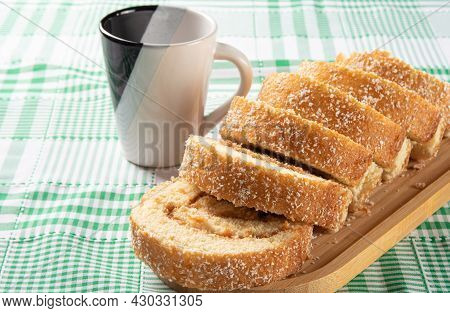 Rocambole, Sliced ​​roacambole Stuffed With Dulce De Leche On A Wooden Tray And A Cup On A Table Wit