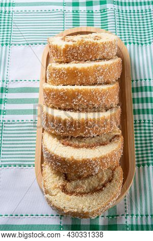 Rocambole, Sliced ​​rocambole Stuffed With Dulce De Leche On A Wooden Tray On A Table With Checkered