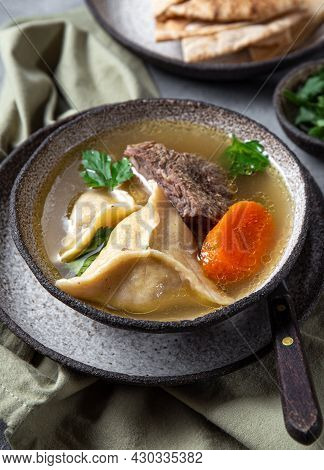 Traditional Jewish Food Dumplingd Kreplach Soup In Gray Bowl.