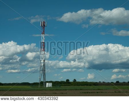 G5 Cell Phone Tower Base Station Against Blue Sky With Clouds. Waves Might Increase The Risk Of Heal