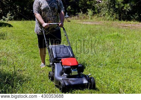 Gardening Activity, Lawn Mower Cutting The Grass Driven Lawn Mower In Sunny Garden