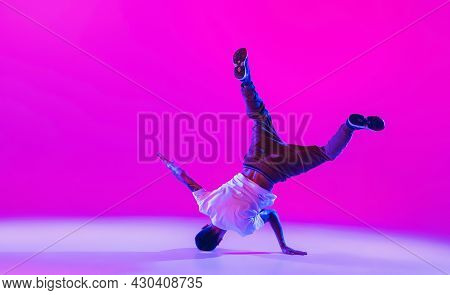 Young Stylish Man, Hip-hop Dancer Dancing Solo In Modern Clothes Isolated Over Bright Magenta Backgr