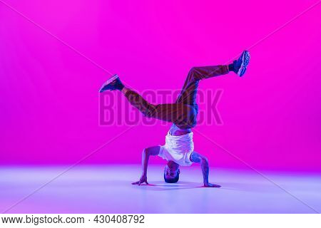 Young Stylish Man, Break Dancing Dancer Practicing Solo In Modern Clothes Isolated Over Bright Magen
