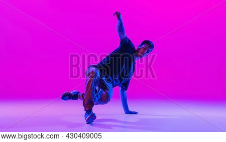Young Stylish Man, Break Dancing Dancer Practicing Solo In Modern Clothes Isolated Over Bright Magen