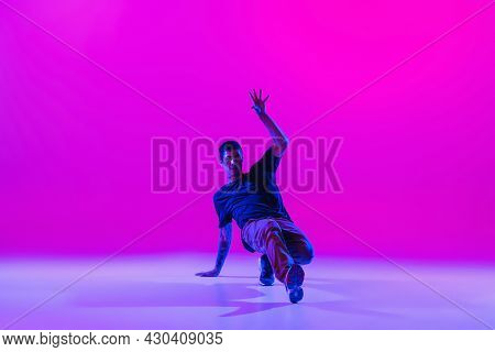 Young Stylish Man, Hip-hop Dancer Dancing Solo In Modern Clothes Isolated Over Bright Magenta Backgr
