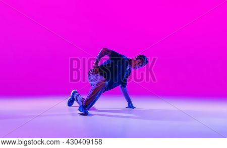 Young Stylish Man, Hip-hop Dancer Dancing Solo In Modern Clothes Isolated Over Bright Magenta Backgr