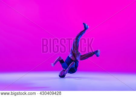 Portrait Of Young Man, Break-dance Dancer Dancing Solo In Modern Clothes Isolated Over Bright Magent