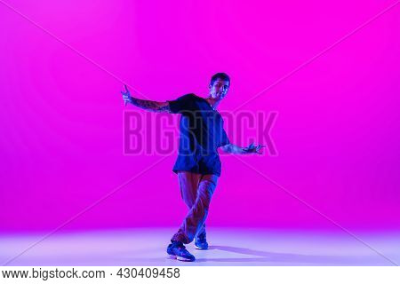 Young Stylish Man, Hip-hop Dancer Dancing Solo In Modern Clothes Isolated Over Bright Magenta Backgr