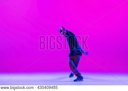 Portrait Of Dancing Man, Break Dancer In Action, Motion In Modern Clothes Isolated Over Bright Magen