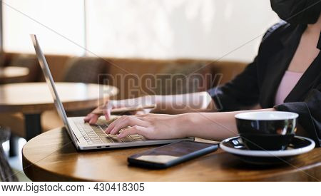 Focus On Hand Young Asian Woman Wearing Face Mask And Using Computer Laptop Workung In Cafe