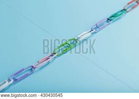 A Chain Of Multi-colored Paper Clips On A Blue Background