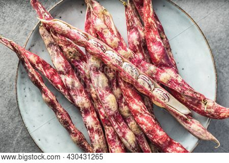Cranberry beans. Borlotti beans. Beans pods on plate. Top view.