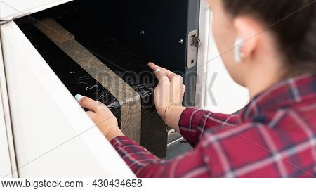 Pickup Parcel. Courier Box In Woman Hands At Post Delivery Automat Terminal. Self Service Post Termi