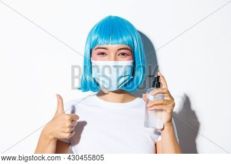 Concept Of Halloween Celebration And Coronavirus. Close-up Of Cute Smiling Asian Girl In Blue Wig An