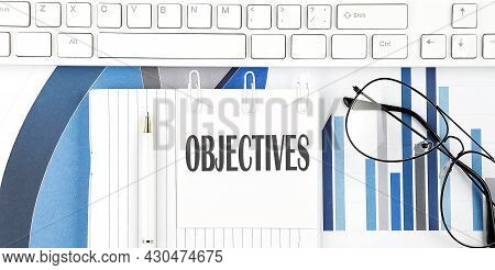 Office Desk Table With Keyboard, Chart,glasses And Pen. Top View With Objectives