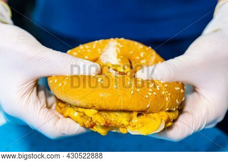 Fast Food. Macro View Of The Burger. Hands In White Latex Gloves Holding Burger, Showing Tasty Chees