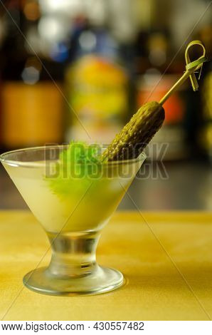 Shaken Vodka And Pickle Juice With Ice In Shot Glass And Garnishing With Small Pickled Cucumber And