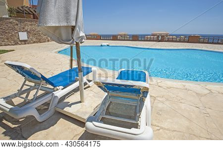 Large Outdoor Swimming Pool At A Luxury Tropical Hotel Resort With Sun Lounger Beds And Sea View