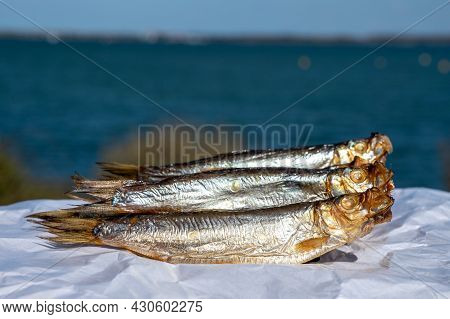 Smoked Sprattus Or Sprats Sea Fish Served Outdoor With View On Blue Sea Water