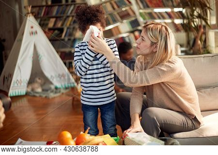 Caucasian nanny babysitting afro american boy at home