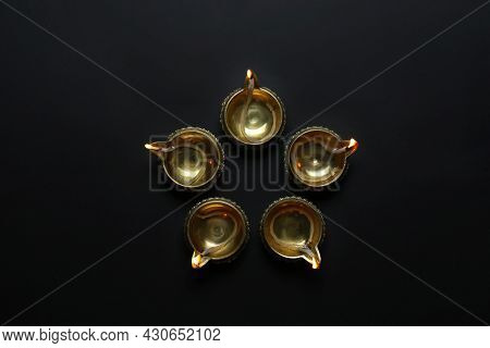 Lit Diyas On Dark Background, Flat Lay. Diwali Lamps
