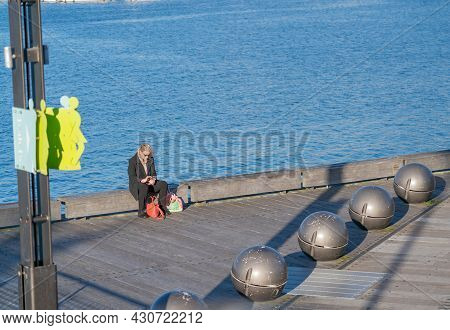 Wellington New Zealand - July 30 2021;woman Sits On Edge Of Great Harbour Way With Jupiter Sphere Bo