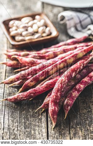 Cranberry beans. Borlotti beans. Beans pods on wooden table.
