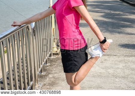 Cropped Shot View Of Runner Woman Doing Stretching And Warming Up Her Legs Before Running In The Par