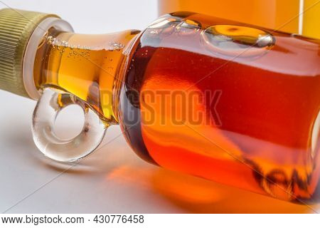 sampler of pure maple syrup - three small glass bottles on a ceramic background