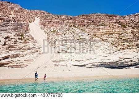 Family of father and  daughter enjoying secluded Gerakas beach accessible only by boat on Greek island of Milos