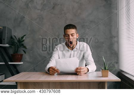 Haggard Caucasian Businessman Yawning Works In The Office With Documents. Fatigue And Lack Of Motiva