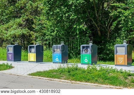 Five Different Waste Sorting Containers On A City Street