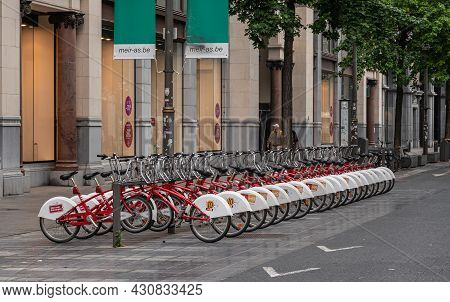Antwerpen, Belgium - August 1, 2021: On Sidewalk Of Meir Blvd, Public Rack Full Of Red-white Bikes F