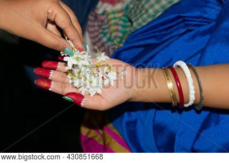 Top Angle View Of Hands With Flowers. Hindu Woman Taking Flowers For Puja In The Temple.