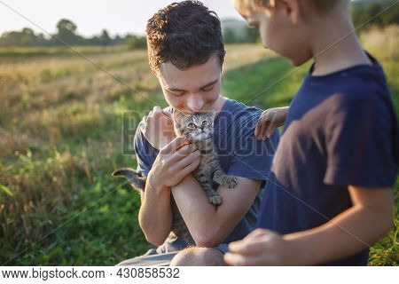 Young Guy Found And Picked Up Little Stripped Kitten During Walking In The Field And Going To Home I