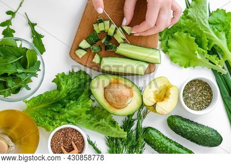 Woman Cooking Salad Of Fresh Green Vegetables And Herbs. Raw Food Concept. Vegan Menu. Cooking Healt