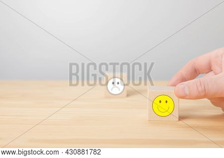 Hand Choose Wooden Cube Block With Icon Face Smile. Man Holds His Finger At A Wooden Cube With Posit
