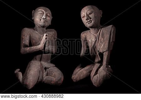 Buddhist Monks In Peaceful Meditation. Traditional Vintage Thai Buddhism Statues. Old Wood Carvings 