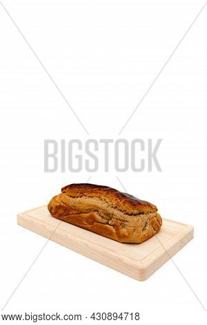 A Homemade Plumcake Standing On A Wooden Board With A White Background
