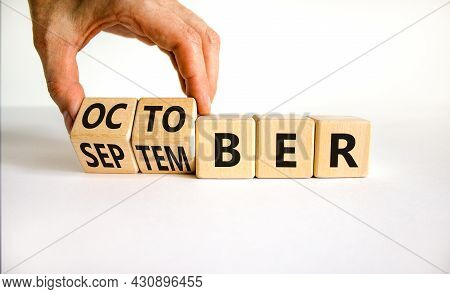 Symbol For The Change From September To October. Businessman Turns Wooden Cubes And Changes The Word
