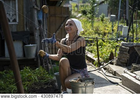 A Russian Woman Juggles Potatoes In A Vegetable Garden In Chistopol, Republic Of Tatarstan Russia. A